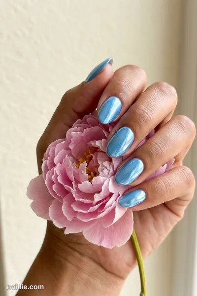 Close-up of oval nails with baby blue polish and a mirror-like chrome finish — look 2