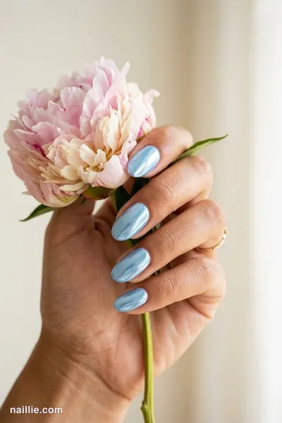 Close-up of oval nails with baby blue polish and a mirror-like chrome finish — look 3