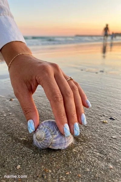 Close-up of short square nails with baby blue marble swirls with gold veins — look 3
