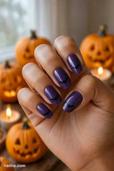 Close-up of oval nails with tiny black bats on deep purple — look 3