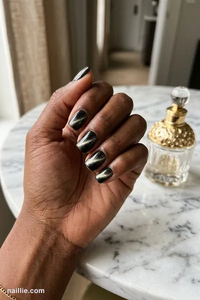 Close-up of short square nails with black polish and a shimmering magnetic cat eye effect — look 3