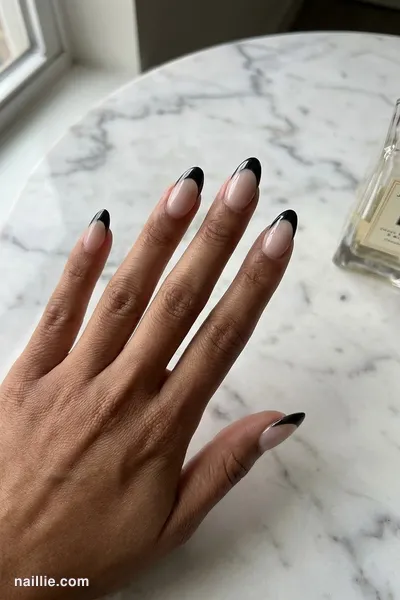 Close-up of almond nails with black chrome French tips