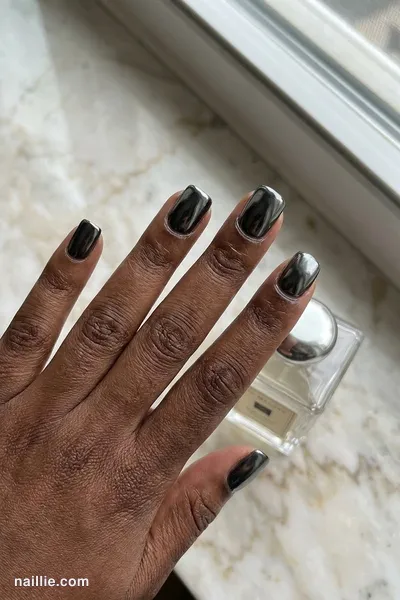 Close-up of short square nails with black polish and a mirror-like chrome finish — look 2