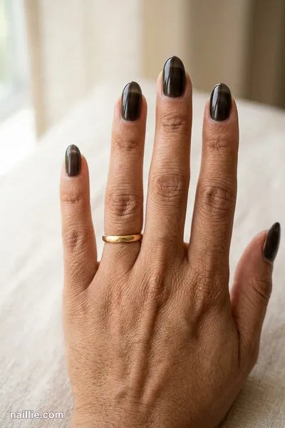 Close-up of oval nails with black polish and a glossy see-through jelly finish — look 3