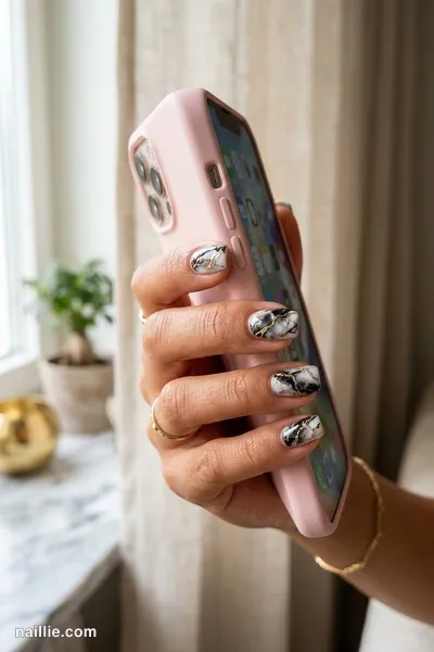 Close-up of short square nails with black marble swirls with gold veins — look 3
