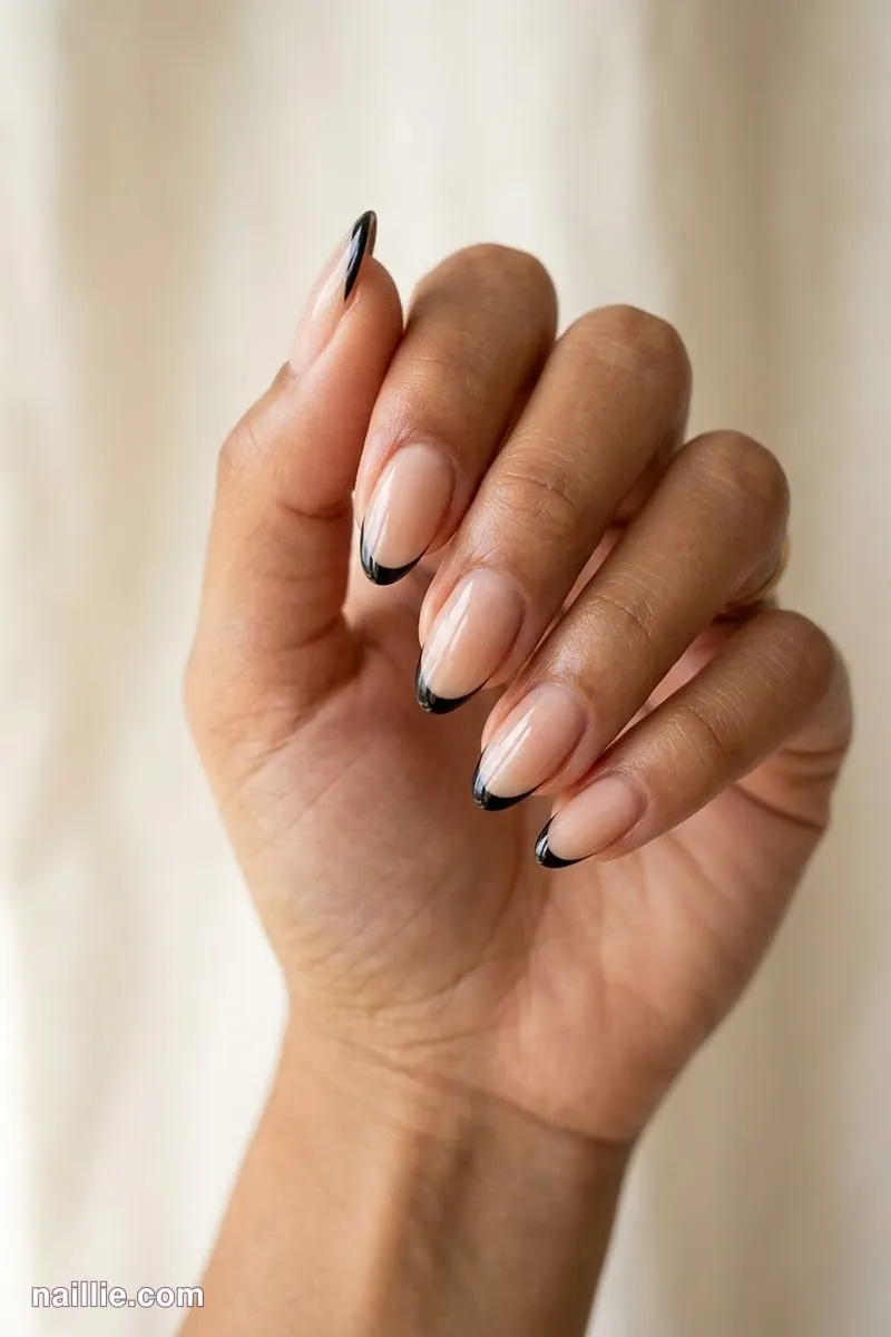 Close-up of almond nails with ultra-thin black micro French tips