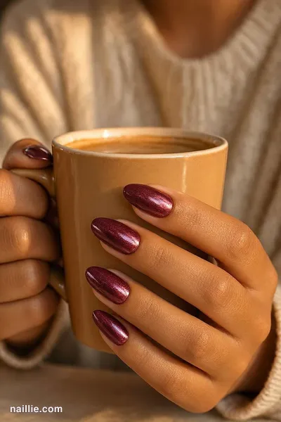 Close-up of almond nails with burgundy polish and a mirror-like chrome finish — look 3