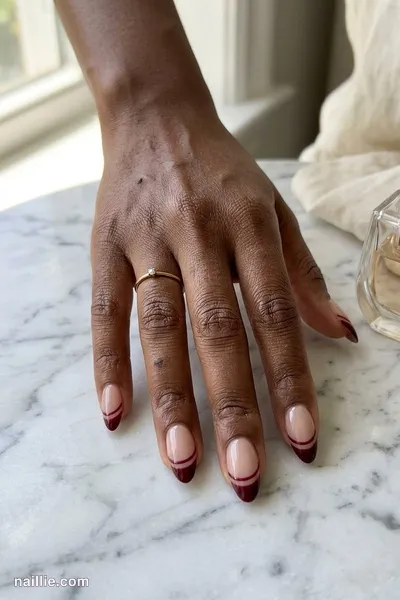 Close-up of almond nails with a burgundy double French line — look 2