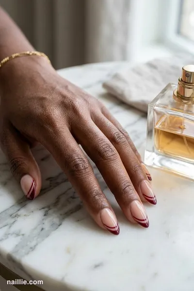Close-up of almond nails with a burgundy double French line — look 3