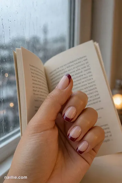 Close-up of short square nails with burgundy French tips over a sheer nude base — look 3
