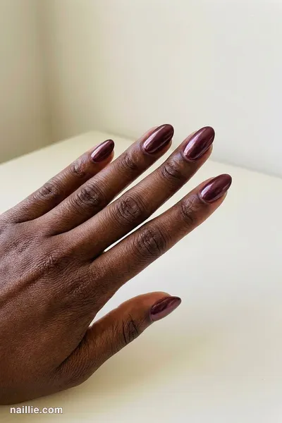 Close-up of oval nails with burgundy polish and a pearly glazed-donut shimmer