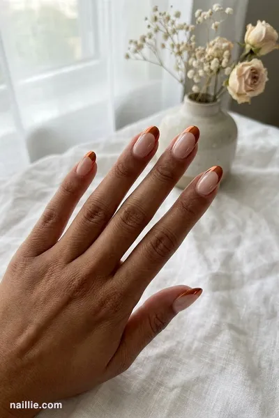 Close-up of oval nails with burnt orange chrome French tips — look 3