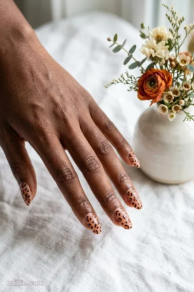 Close-up of oval nails with burnt orange leopard print spots