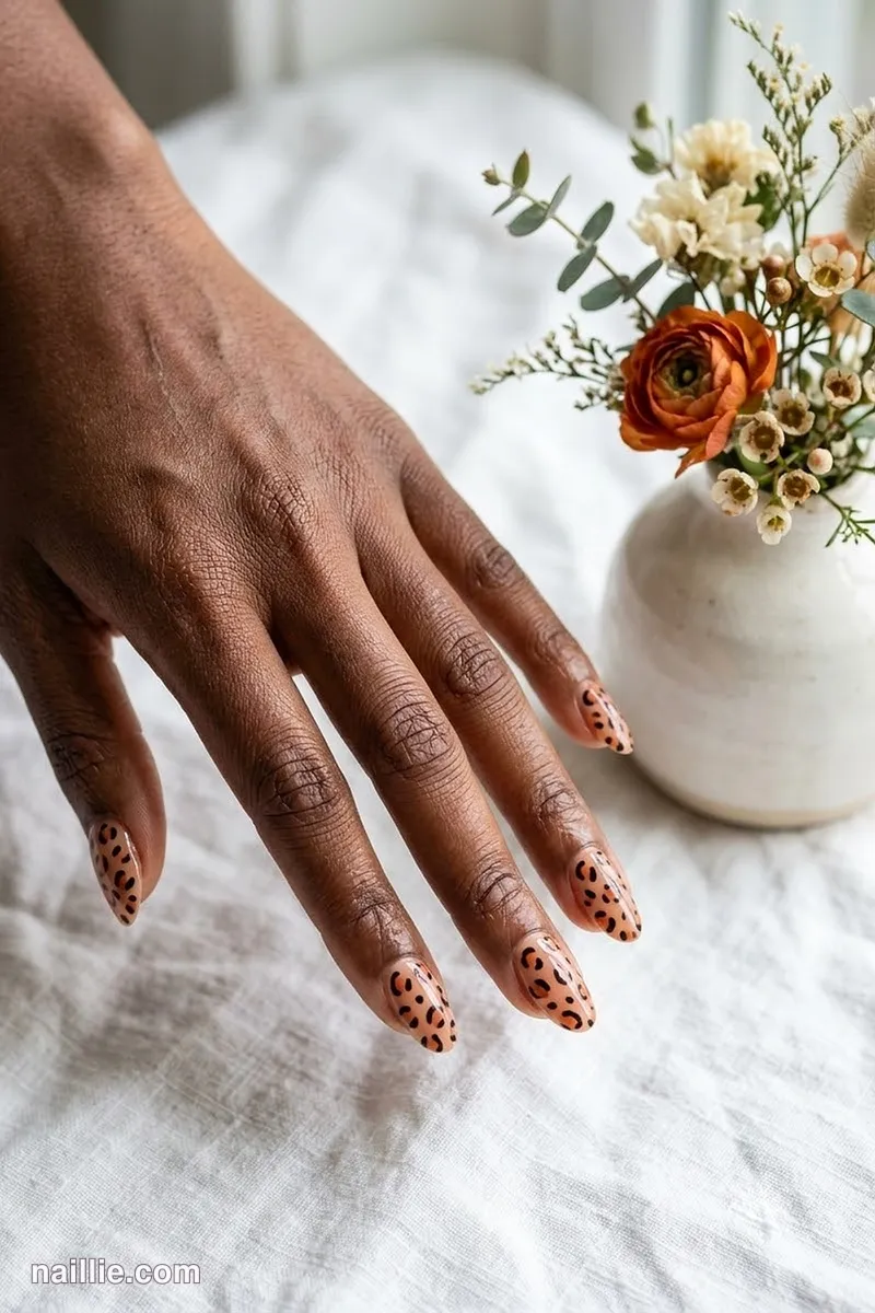 Close-up of oval nails with burnt orange leopard print spots