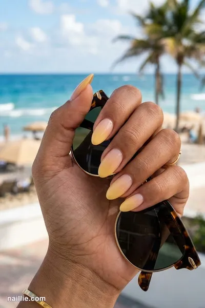 Close-up of almond nails with a butter yellow ombre fading into nude — look 3