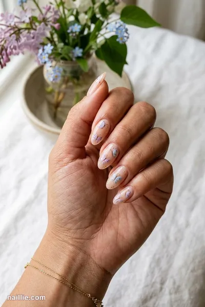 Close-up of almond nails with delicate painted butterflies