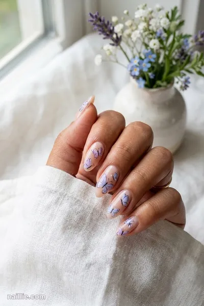 Close-up of almond nails with delicate painted butterflies — look 2