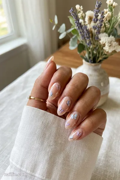 Close-up of almond nails with delicate painted butterflies — look 3