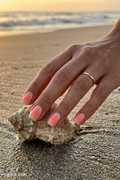 Close-up of short square nails with a glowing coral aura in the center — look 3