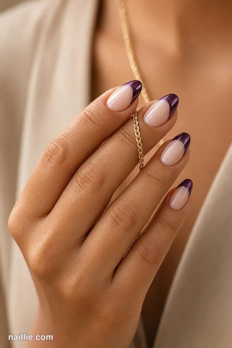 Close-up of oval nails with deep plum chrome French tips