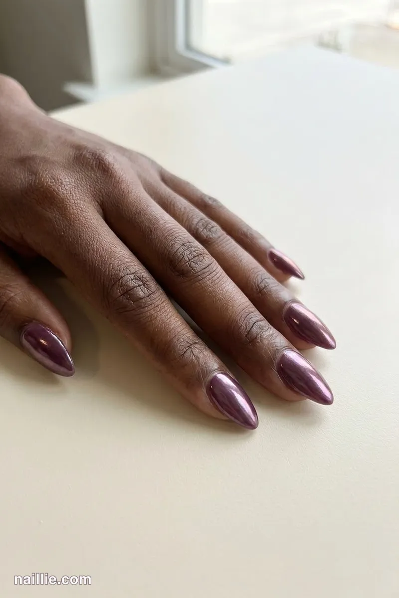 Close-up of almond nails with deep plum polish and a pearly glazed-donut shimmer