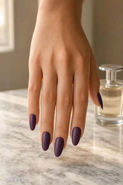 Close-up of almond nails with deep plum polish and a soft matte top coat — look 2