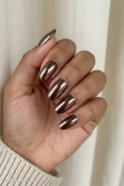 Close-up of oval nails with espresso brown polish and a mirror-like chrome finish — look 3