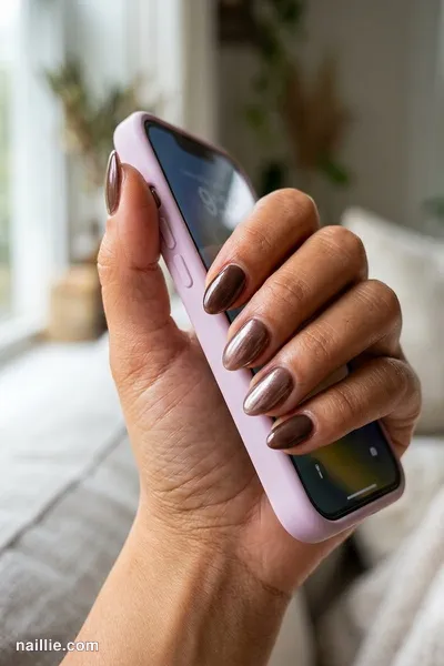 Close-up of short almond nails with espresso brown polish and a pearly glazed-donut shimmer — look 2
