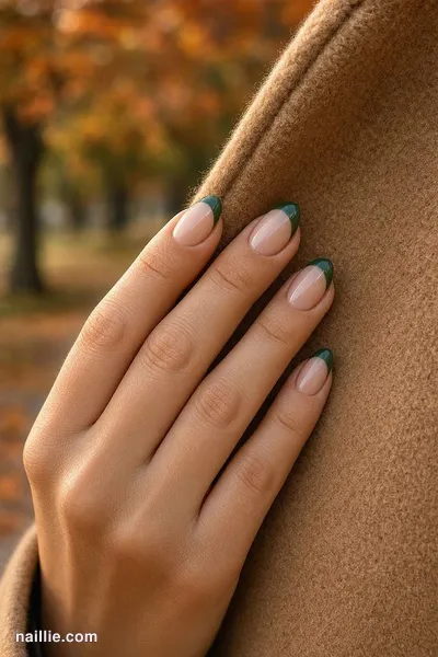 Close-up of oval nails with forest green French tips over a sheer nude base — look 2