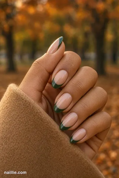 Close-up of oval nails with forest green French tips over a sheer nude base — look 4