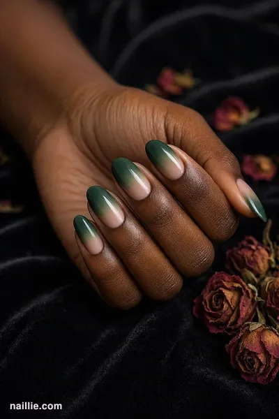 Close-up of oval nails with a forest green ombre fading into nude
