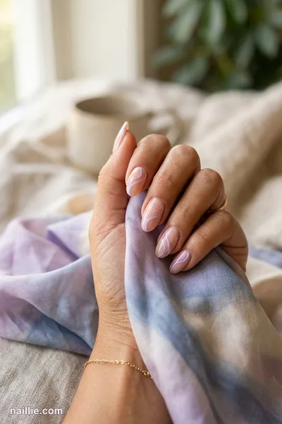 Close-up of oval nails with lilac abstract swirls on a nude base