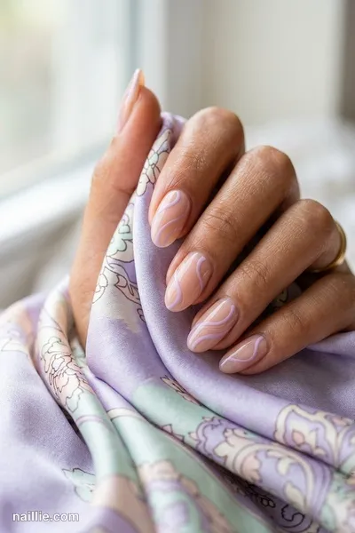Close-up of oval nails with lilac abstract swirls on a nude base — look 2