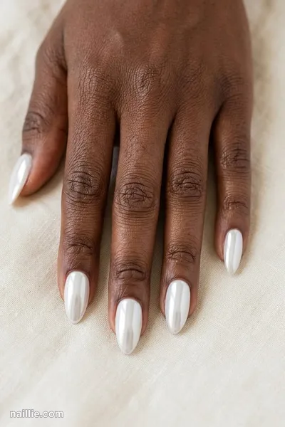 Close-up of almond nails with milky white polish and a mirror-like chrome finish — look 2