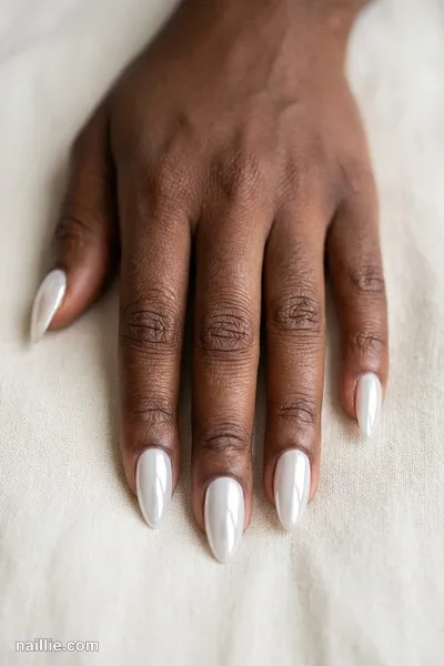 Close-up of almond nails with milky white polish and a mirror-like chrome finish — look 3