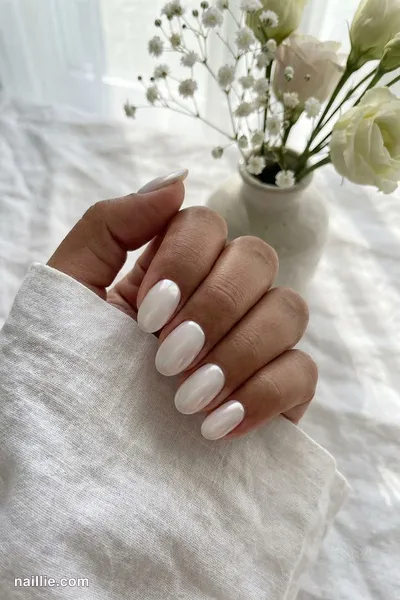 Close-up of oval nails with milky white polish and a pearly glazed-donut shimmer — look 2