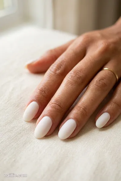 Close-up of oval nails with milky white polish and a soft matte top coat — look 3