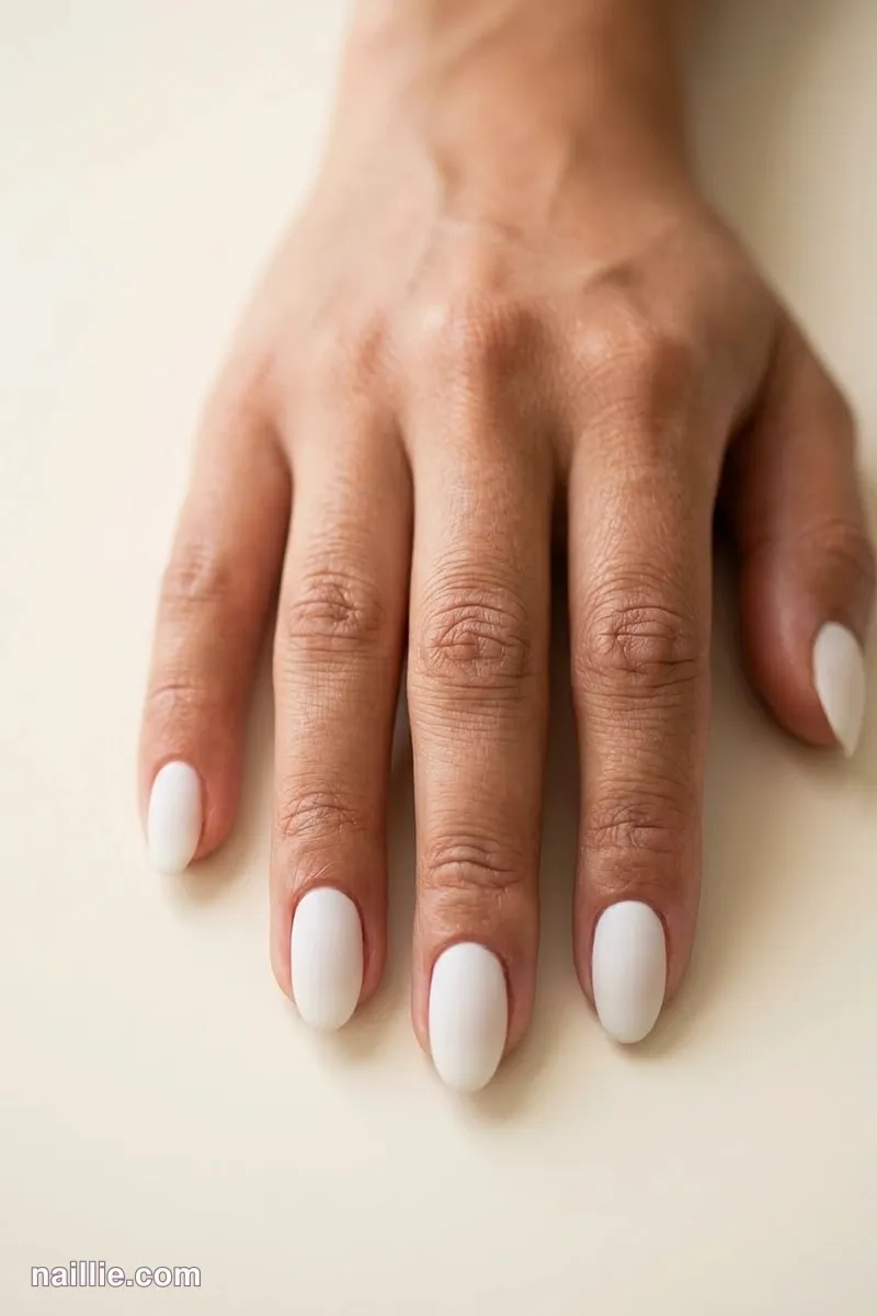 Close-up of oval nails with milky white polish and a soft matte top coat