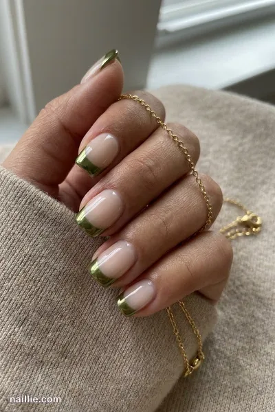 Close-up of short square nails with olive green chrome French tips