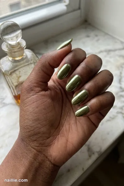 Close-up of oval nails with olive green polish and a mirror-like chrome finish — look 2