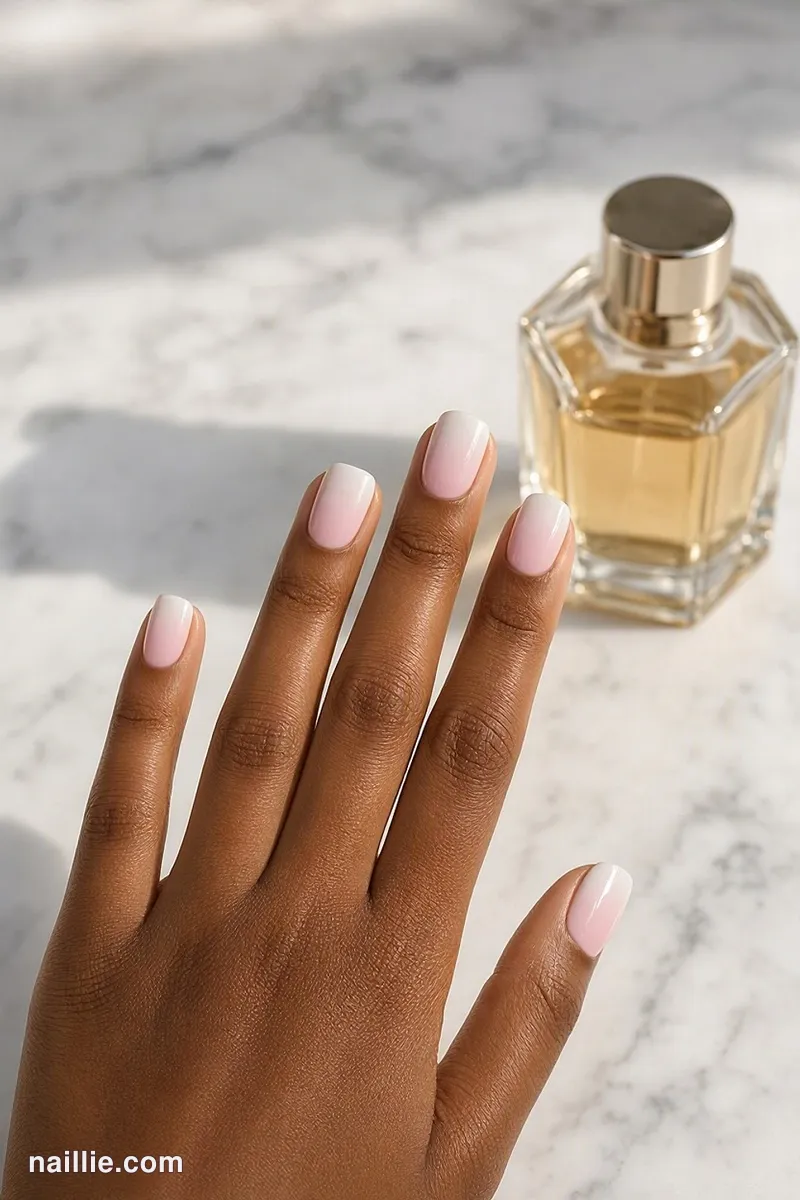 Close-up of short square nails with a soft pastel pink baby boomer fade