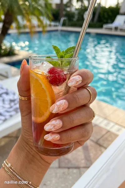 Close-up of oval nails with peach marble swirls with gold veins — look 2