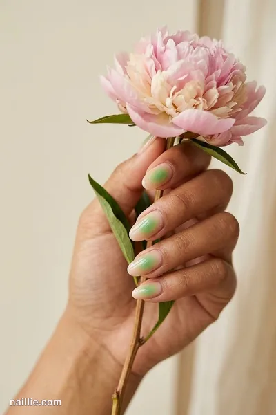 Close-up of oval nails with a glowing sage green aura in the center