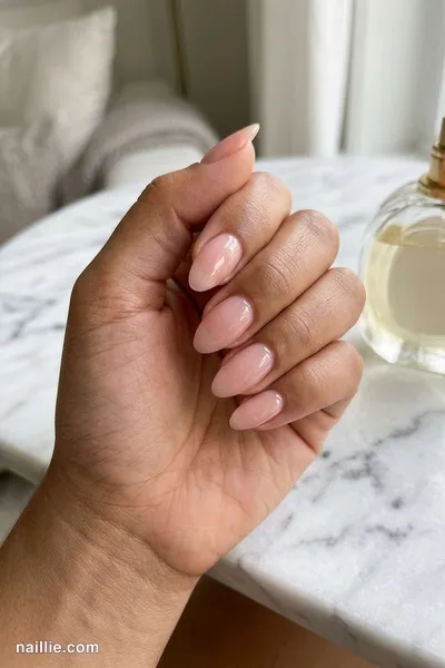 Close-up of almond nails with soft pink nude polish and a glossy see-through jelly finish — look 2