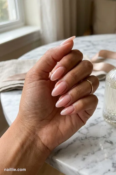 Close-up of almond nails with soft pink nude polish and a glossy see-through jelly finish — look 3