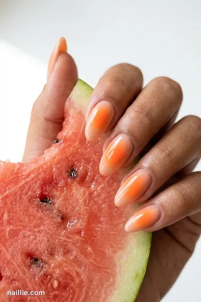 Close-up of almond nails with a glowing sunset orange aura in the center