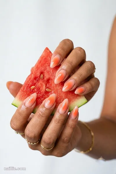 Close-up of almond nails with a glowing sunset orange aura in the center — look 3