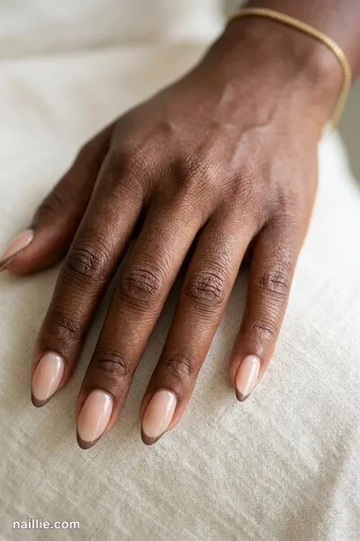 Close-up of almond nails with ultra-thin taupe micro French tips