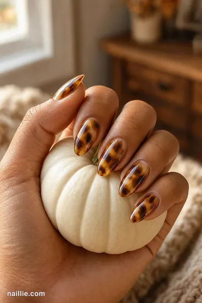 Close-up of almond nails with glossy amber-and-brown tortoiseshell print — look 2