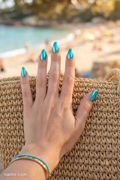 Close-up of almond nails with turquoise polish and a mirror-like chrome finish — look 3